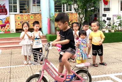 Hoạt động ngoài trời của các em bé lớp A2: Quan sát mô hình ngã tư đường phố tại sân trường